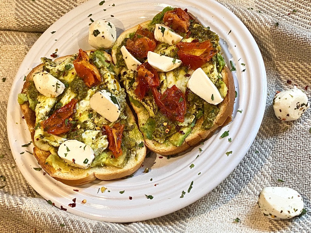 The VIRAL Pesto Fried Eggs Laid Over Avocado Toast And Topped With Marinated Mozzarella & Sun-dried&nbsp;Tomatoes.